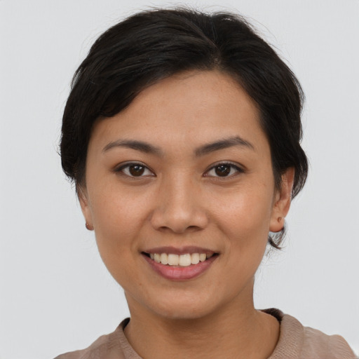 Joyful asian young-adult female with short  brown hair and brown eyes