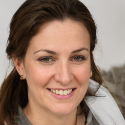 Joyful white adult female with medium  brown hair and grey eyes