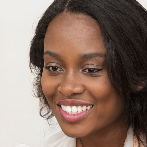 Joyful black young-adult female with long  black hair and brown eyes