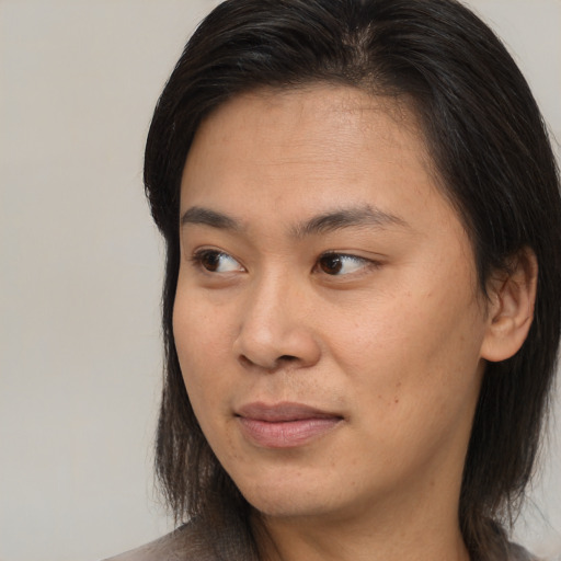 Joyful asian young-adult female with long  brown hair and brown eyes