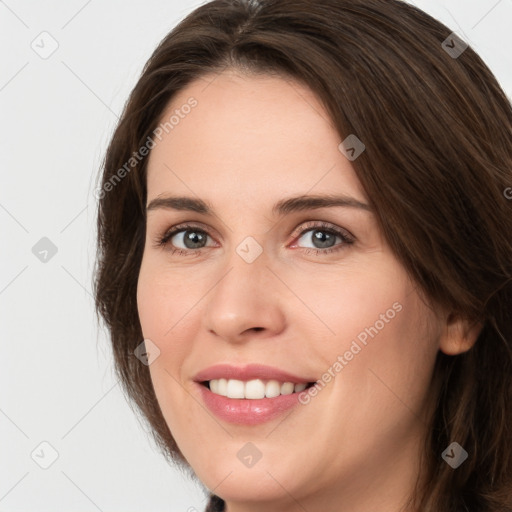 Joyful white young-adult female with long  brown hair and grey eyes