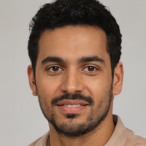 Joyful latino young-adult male with short  black hair and brown eyes