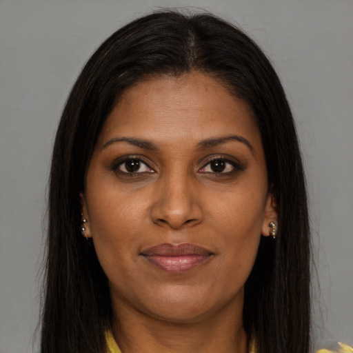 Joyful black young-adult female with long  brown hair and brown eyes