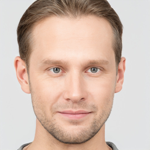 Joyful white young-adult male with short  brown hair and grey eyes