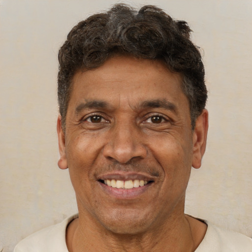 Joyful latino adult male with short  brown hair and brown eyes