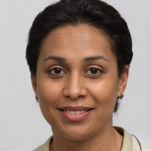 Joyful latino adult female with short  brown hair and brown eyes