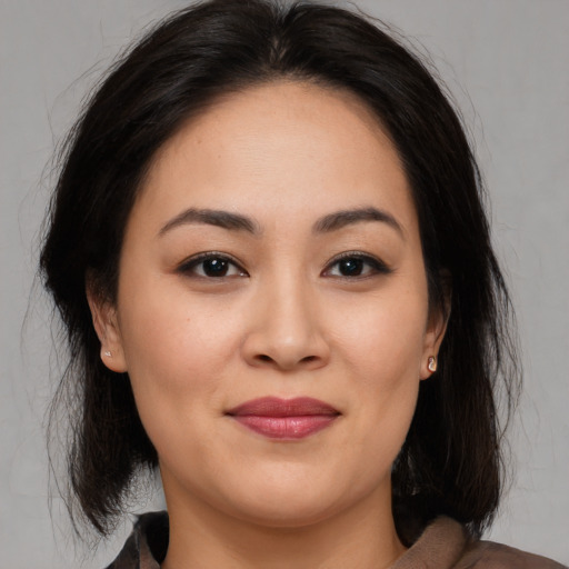 Joyful asian young-adult female with medium  brown hair and brown eyes