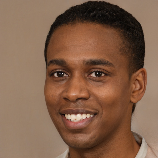 Joyful black young-adult male with short  brown hair and brown eyes
