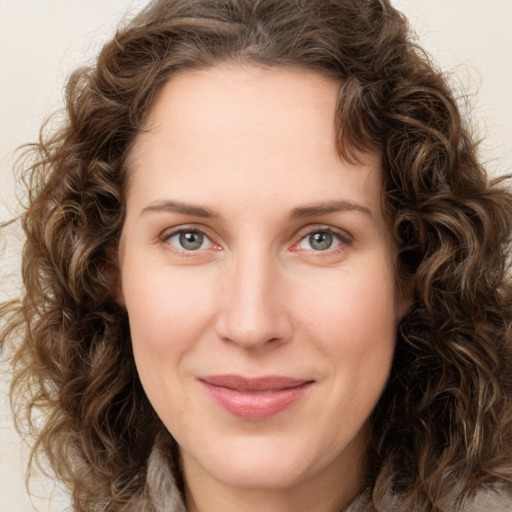 Joyful white young-adult female with long  brown hair and green eyes