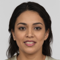 Joyful latino young-adult female with medium  brown hair and brown eyes