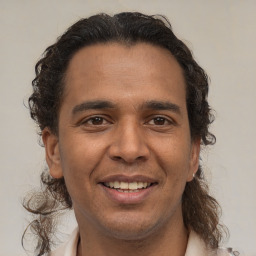 Joyful latino young-adult male with short  brown hair and brown eyes