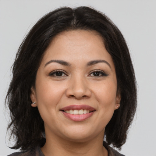Joyful latino young-adult female with medium  brown hair and brown eyes