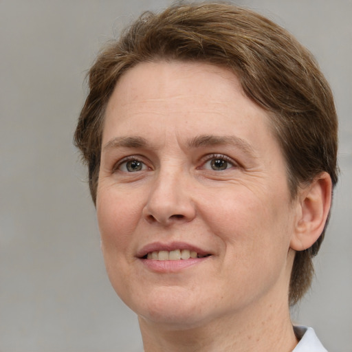 Joyful white adult female with medium  brown hair and grey eyes