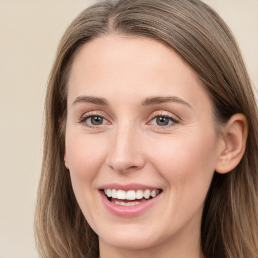 Joyful white young-adult female with long  brown hair and grey eyes