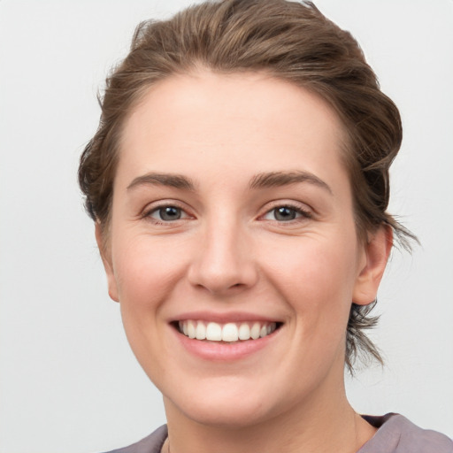 Joyful white young-adult female with short  brown hair and grey eyes