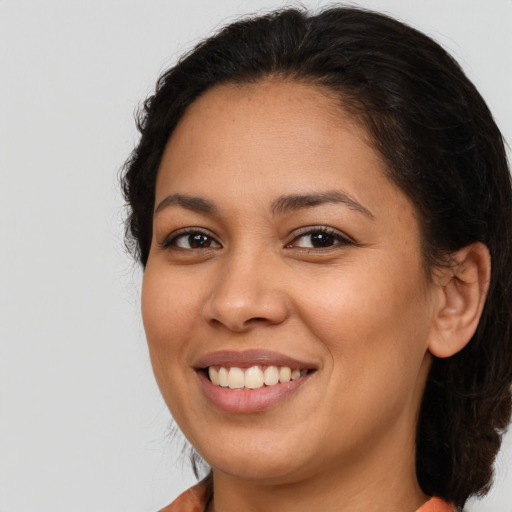 Joyful latino young-adult female with medium  brown hair and brown eyes