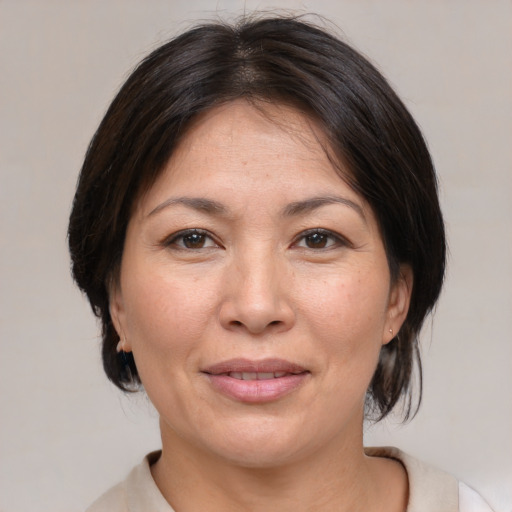 Joyful asian adult female with medium  brown hair and brown eyes