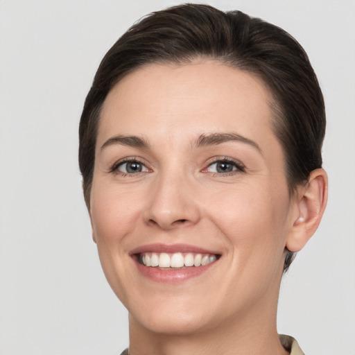 Joyful white young-adult female with short  brown hair and grey eyes