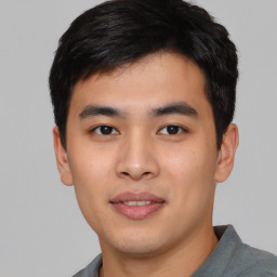 Joyful asian young-adult male with short  black hair and brown eyes