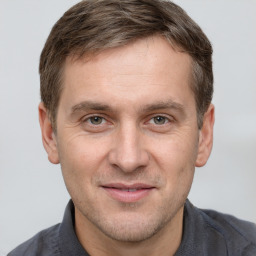 Joyful white adult male with short  brown hair and grey eyes