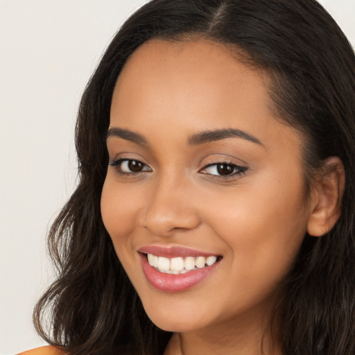 Joyful latino young-adult female with long  brown hair and brown eyes