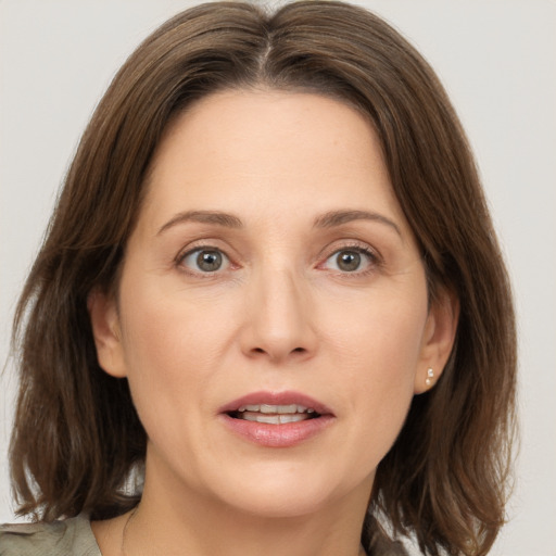 Joyful white adult female with medium  brown hair and grey eyes