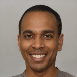 Joyful black adult male with short  black hair and brown eyes