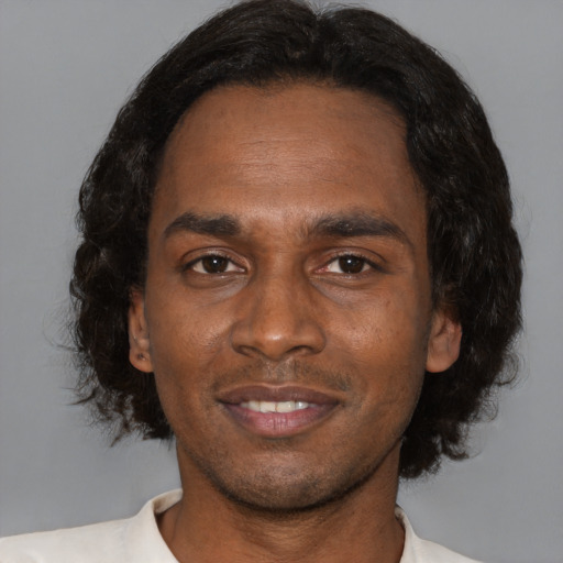 Joyful black adult male with short  brown hair and brown eyes