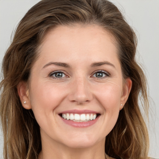 Joyful white young-adult female with long  brown hair and grey eyes