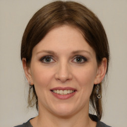 Joyful white young-adult female with medium  brown hair and grey eyes