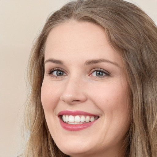 Joyful white adult female with long  brown hair and green eyes