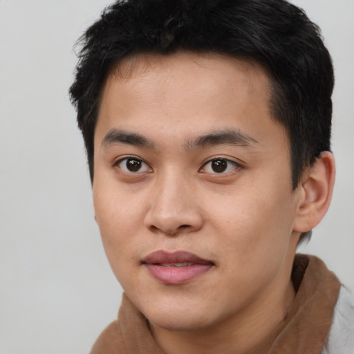 Joyful asian young-adult male with short  brown hair and brown eyes
