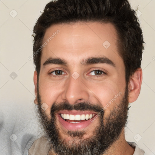 Joyful white young-adult male with short  black hair and brown eyes