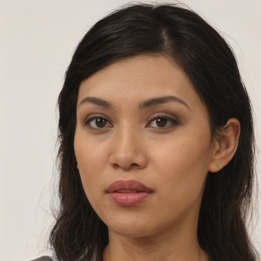 Joyful latino young-adult female with long  brown hair and brown eyes