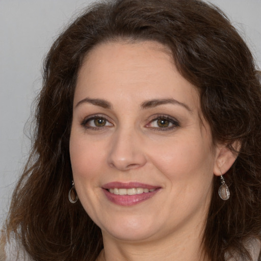 Joyful white adult female with long  brown hair and brown eyes