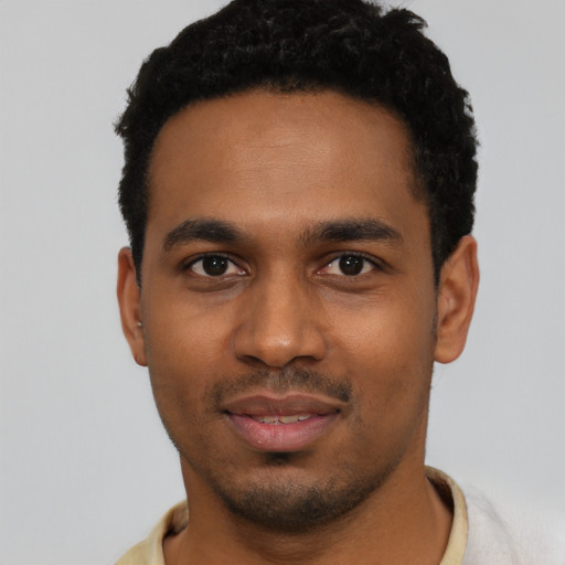 Joyful black young-adult male with short  black hair and brown eyes