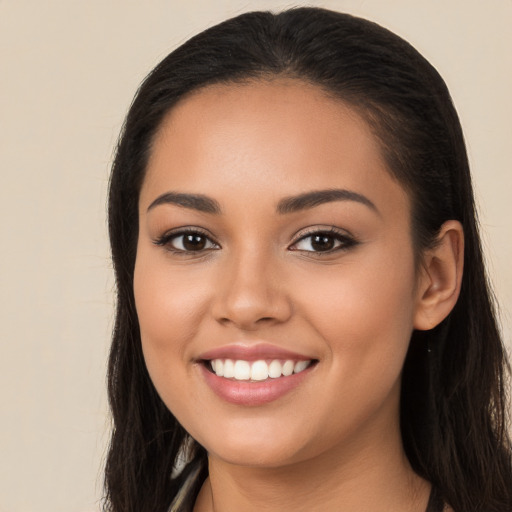 Joyful latino young-adult female with long  brown hair and brown eyes