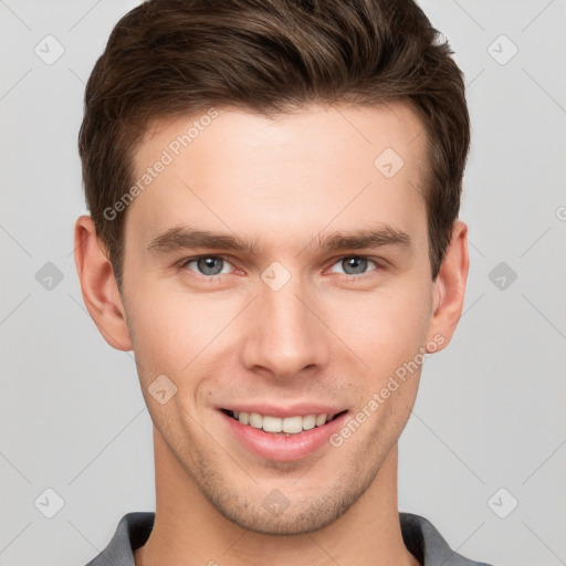 Joyful white young-adult male with short  brown hair and grey eyes