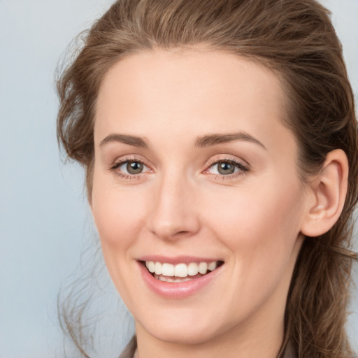 Joyful white young-adult female with medium  brown hair and grey eyes