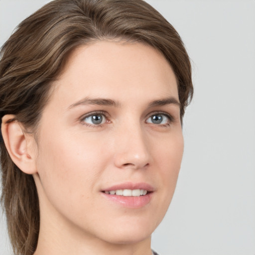 Joyful white young-adult female with medium  brown hair and grey eyes