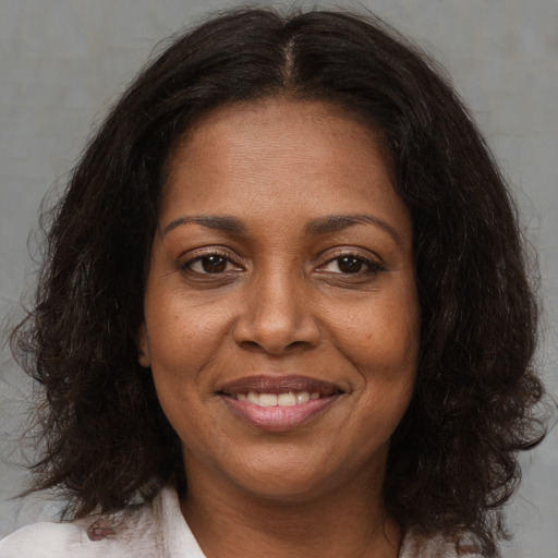Joyful black adult female with medium  brown hair and brown eyes