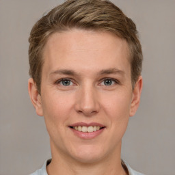 Joyful white young-adult male with short  brown hair and grey eyes