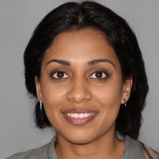 Joyful black young-adult female with medium  black hair and brown eyes