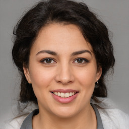 Joyful latino young-adult female with medium  brown hair and brown eyes