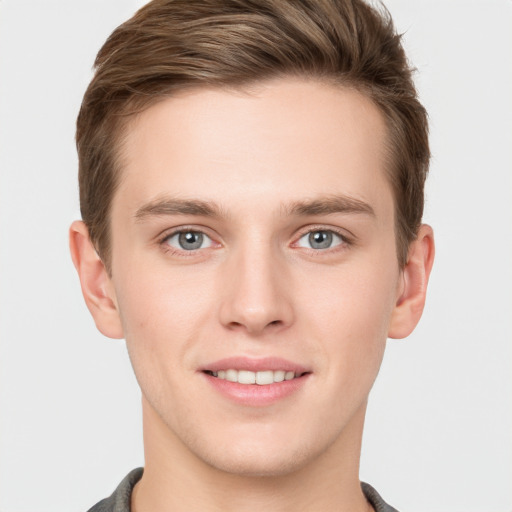 Joyful white young-adult male with short  brown hair and grey eyes