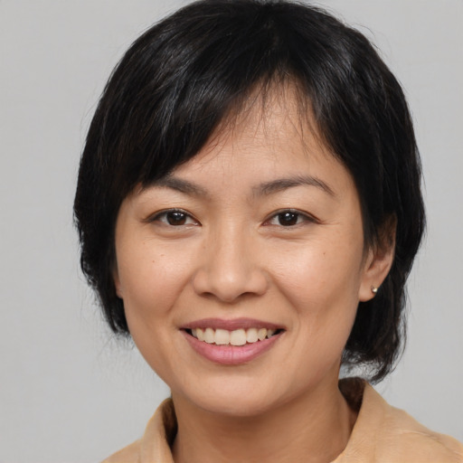 Joyful asian adult female with medium  brown hair and brown eyes