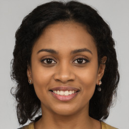 Joyful black young-adult female with long  brown hair and brown eyes