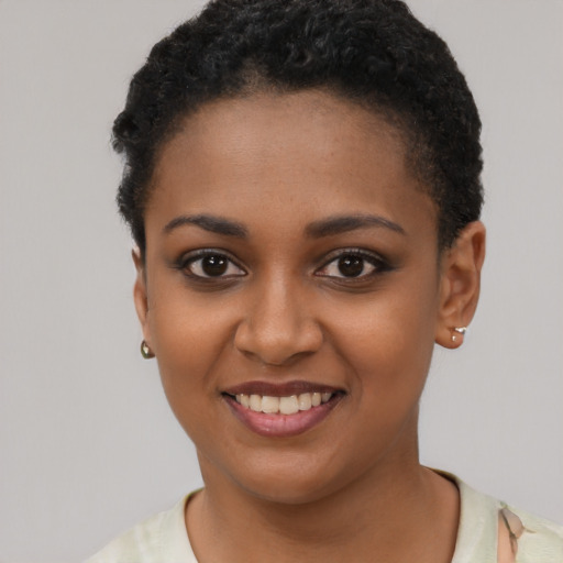 Joyful black young-adult female with short  brown hair and brown eyes