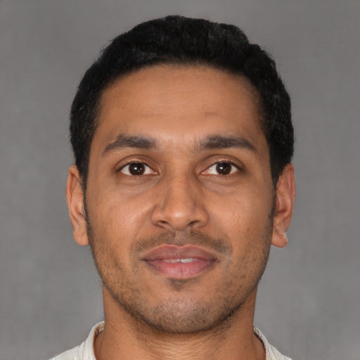 Joyful latino young-adult male with short  black hair and brown eyes