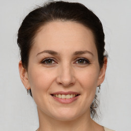 Joyful white adult female with medium  brown hair and grey eyes